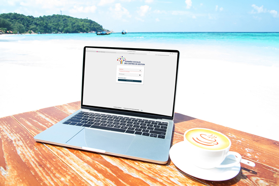 Ordinateur portable avec une tasse à café devant une plage